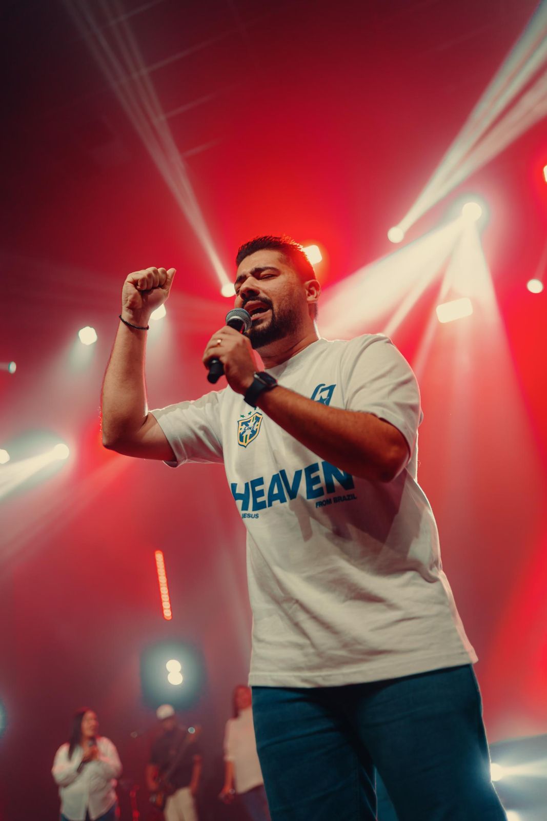 Cantor com camisa Heaven com mão levantada
